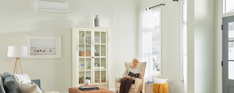 Woman reading beneath wall-mounted mini split